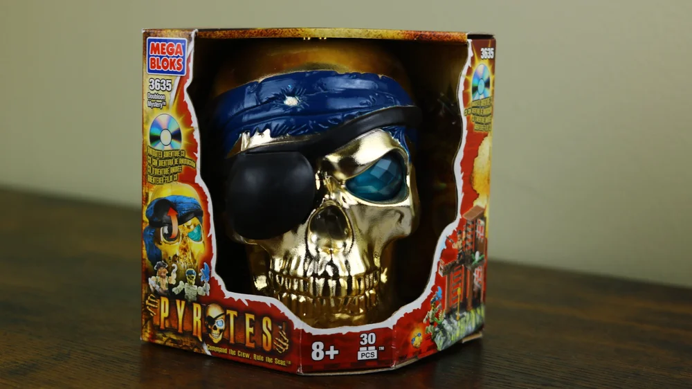 Miscellaneous: themed packaging, gold skull face w/ blue bandana