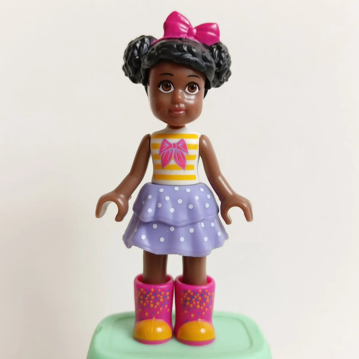 Kendall, white shirt with pink bow tie and yellow stripes, lavender tiered skirt, pink wellington boots, pink bow tie