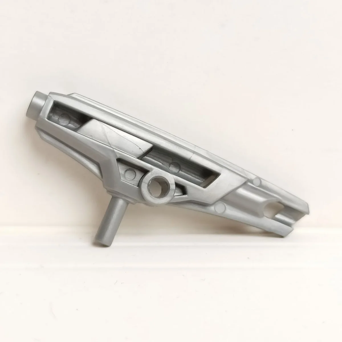 Minifigure Gun (large curved laser blaster), with bar insert in Gray, Light (Metallic)