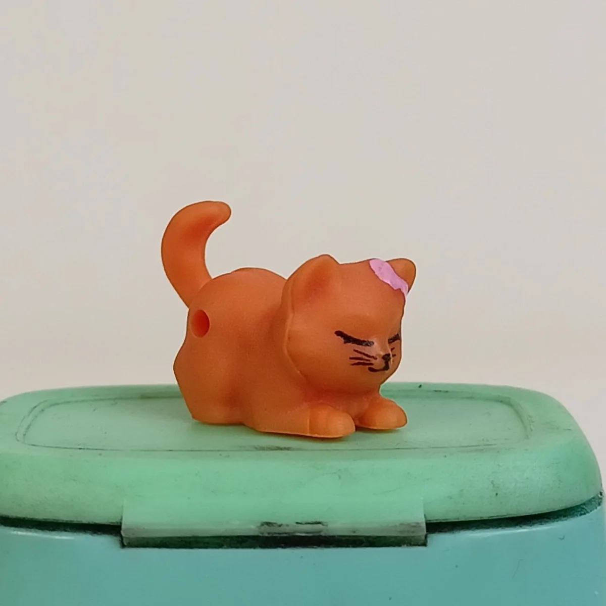 Kitten, sleeping, peg hole on the right side of the lower half (light orange with pink bow pattern)