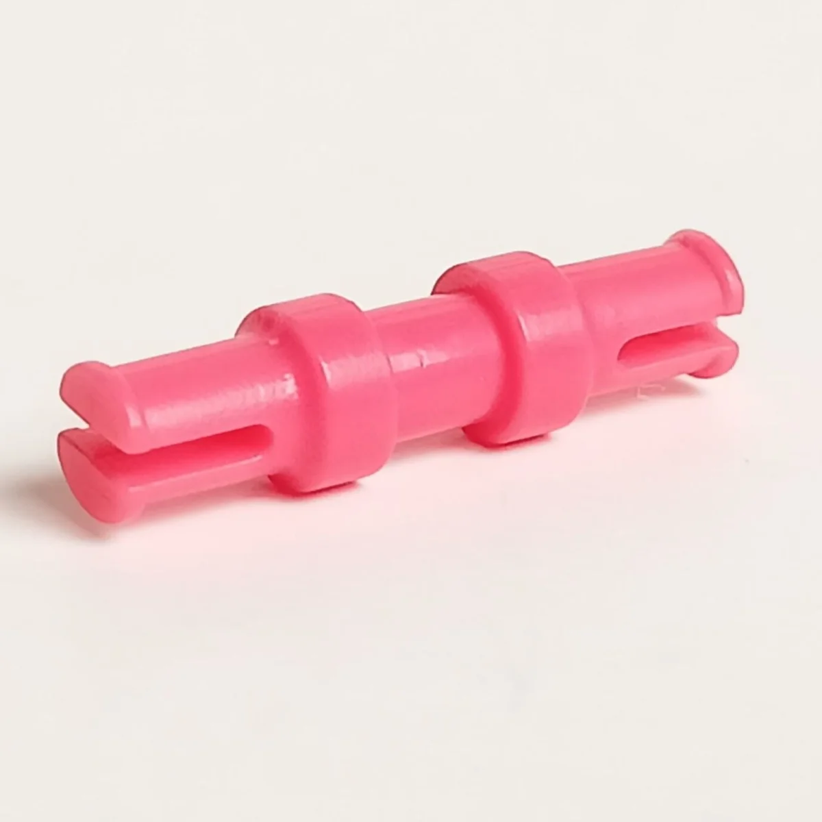Connector: axle 2 studs long with central grip in Pink, Rich