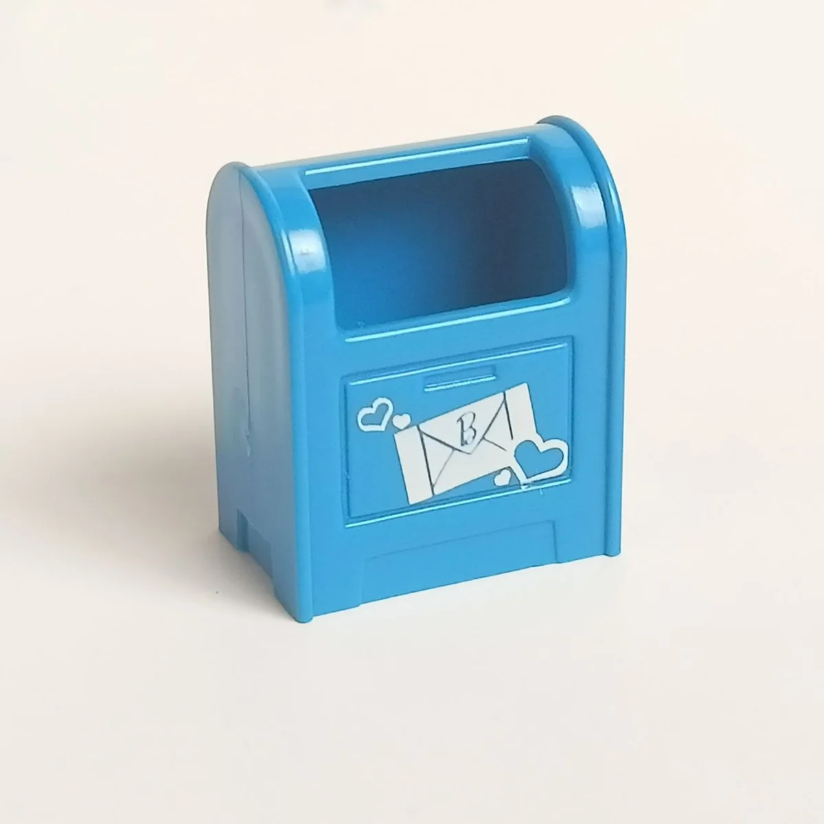 2 x 3 letterbox with white mail piece with a barbie logo surrounded by hearts pattern in Blue, Spanish