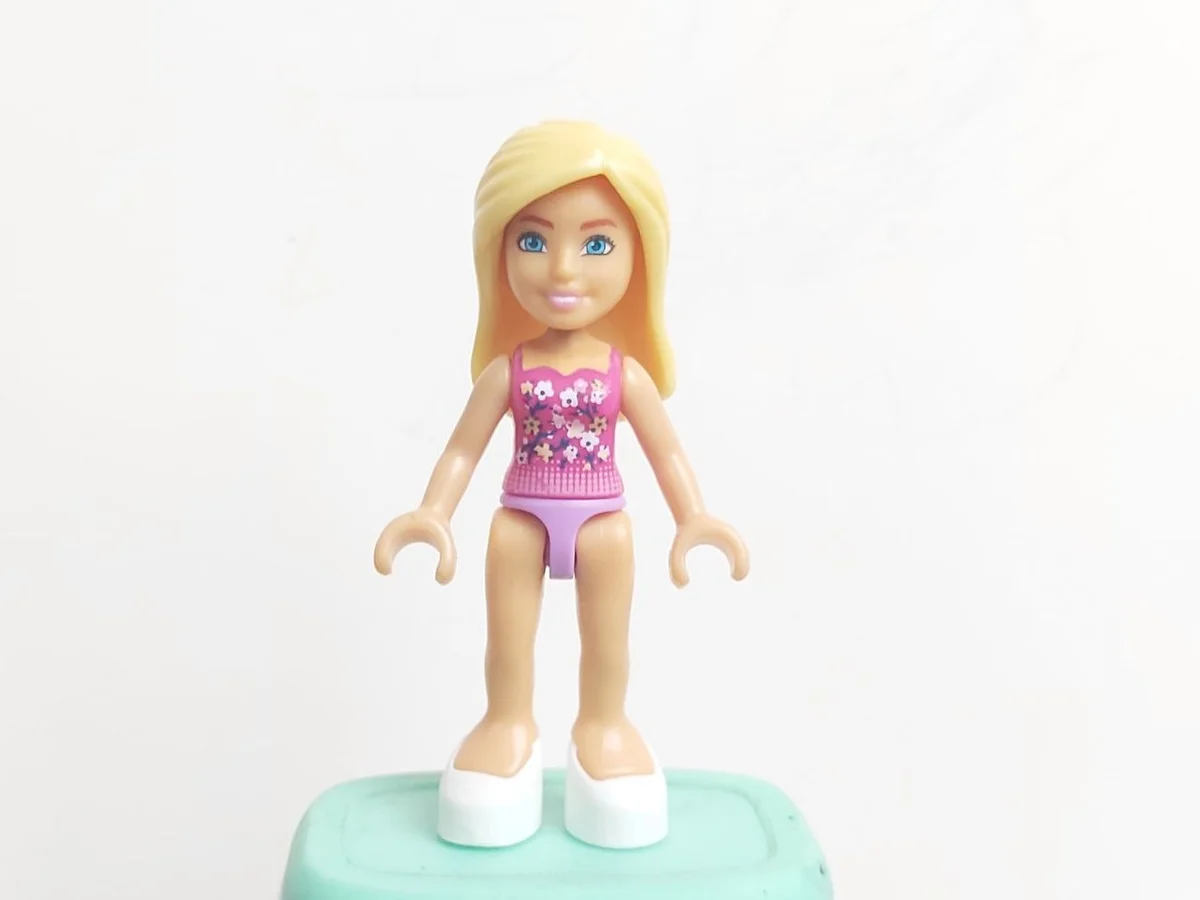 Barbie Micro-Doll, Barbie pink swim shirt with white flowers on black twigs pattern with light pink lower pattern, lavender hips, long flowy blond hair, blue eyes, white slippers,
