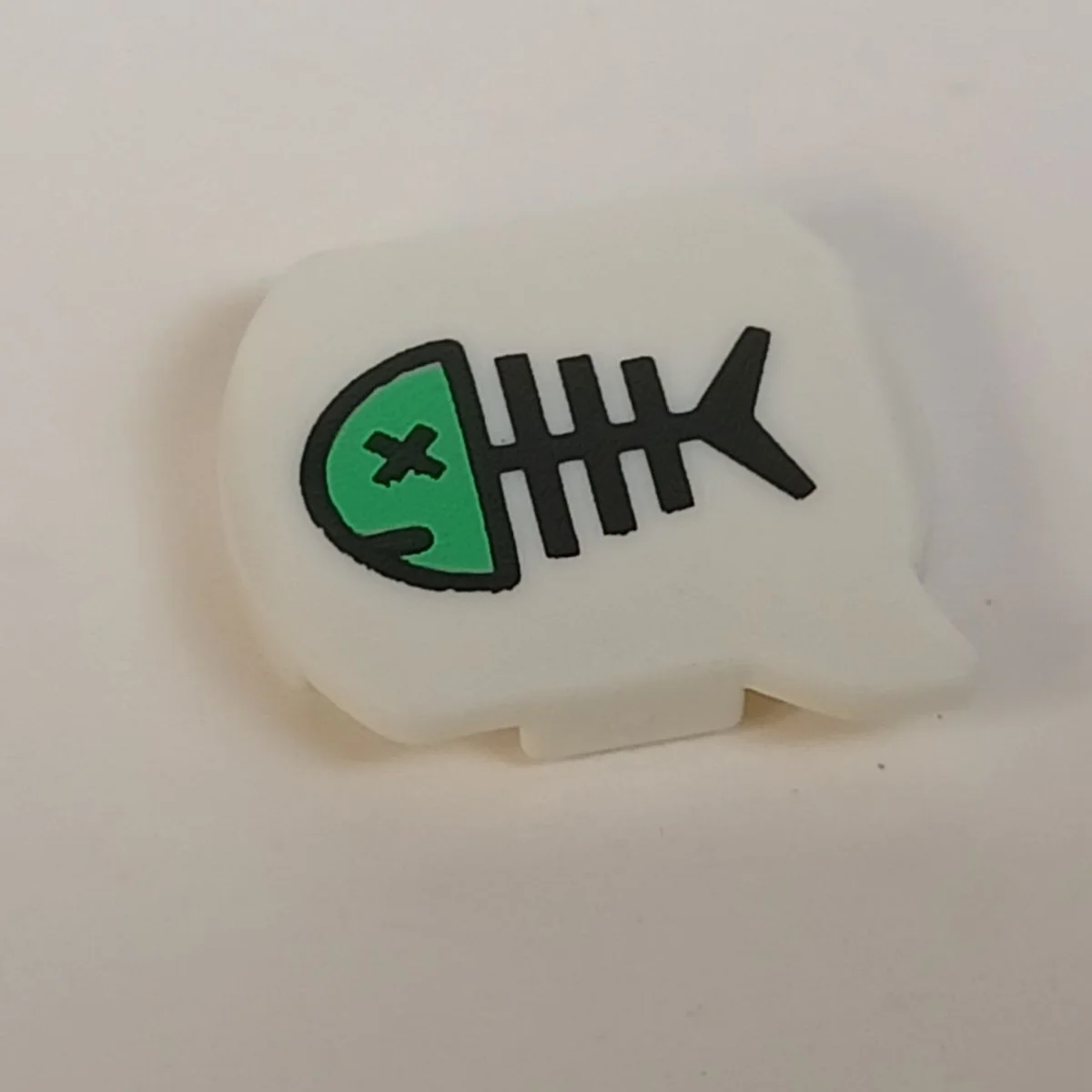speech bubble, printed with teal fish sceleton with crossed eye in White