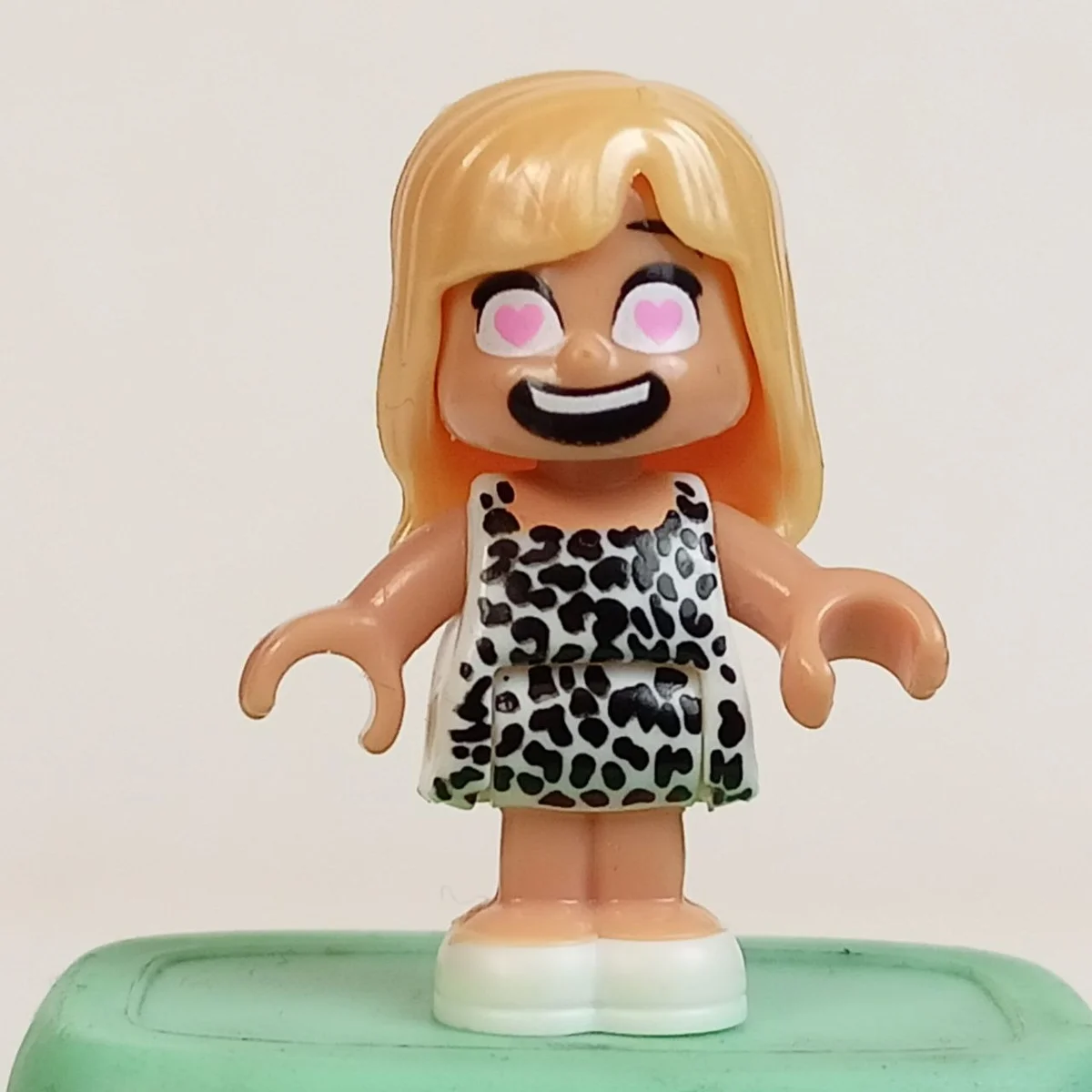 Yootz figure, female, gold blond hair, heart shaped eyes, white dress with black leopard pattern